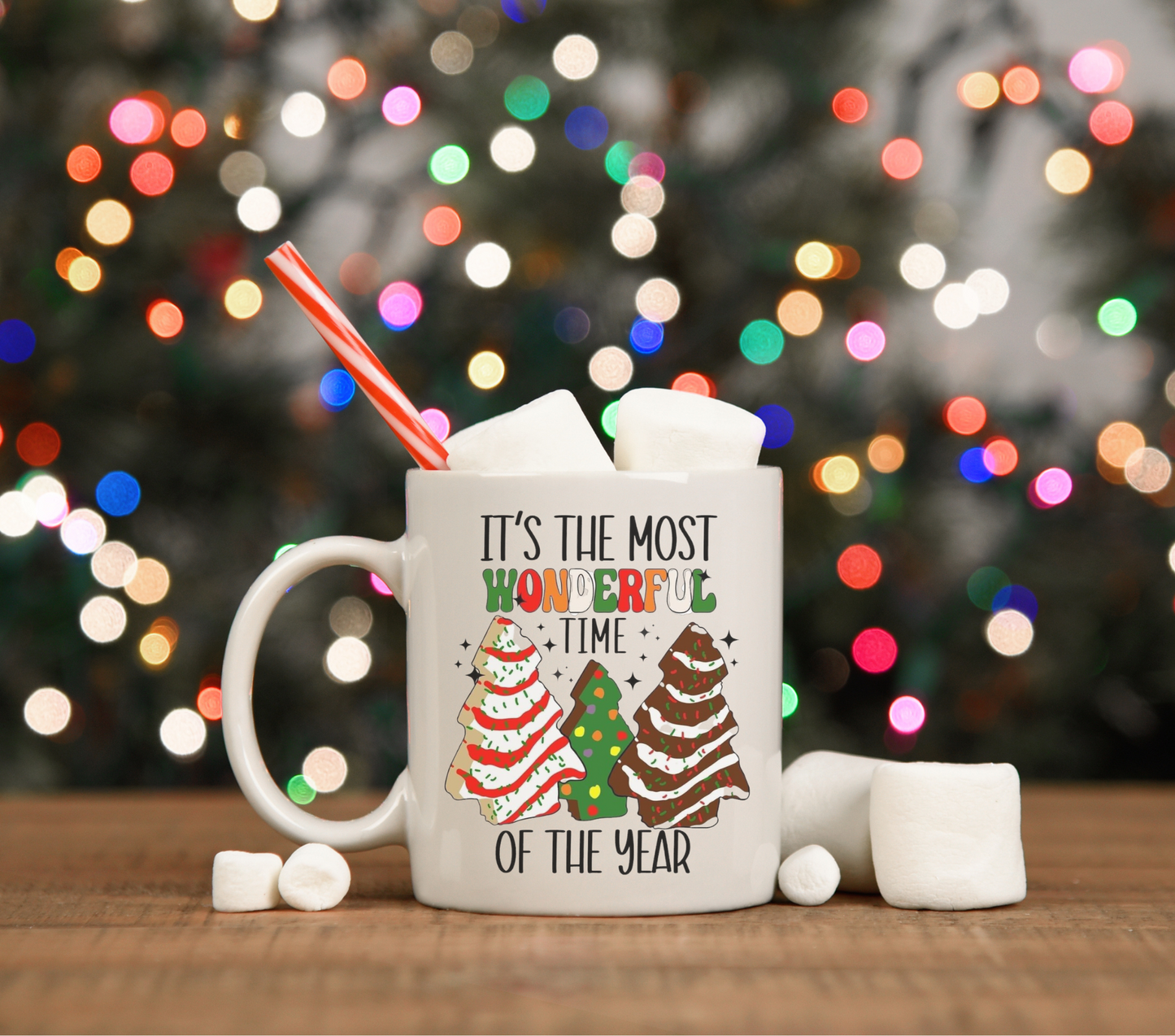 15oz ceramic coffee mug featuring the phrase 'It's the Most Wonderful Time of the Year' with a colorful illustration of Christmas tree cakes, perfect for festive holiday beverages.