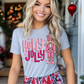 Woman wearing a Christmas shirt with pink "Holly Jolly" text and nutcracker design.