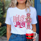 Woman wearing a Christmas shirt with pink "Holly Jolly" text and nutcracker design.