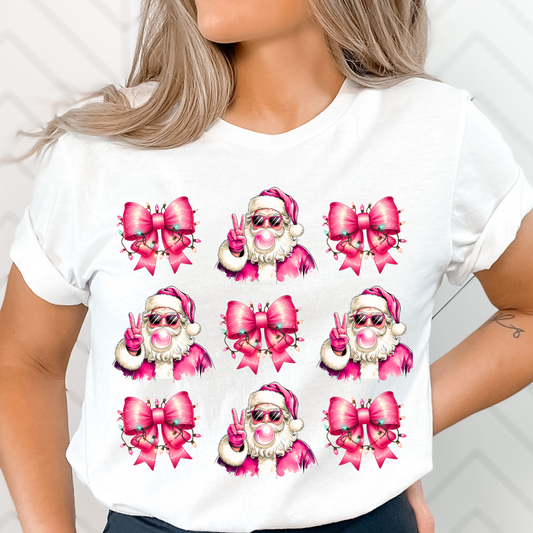 Unisex white t-shirt featuring a pink Santa blowing bubblegum, adorned with coquette bows wrapped in glowing pink Christmas lights