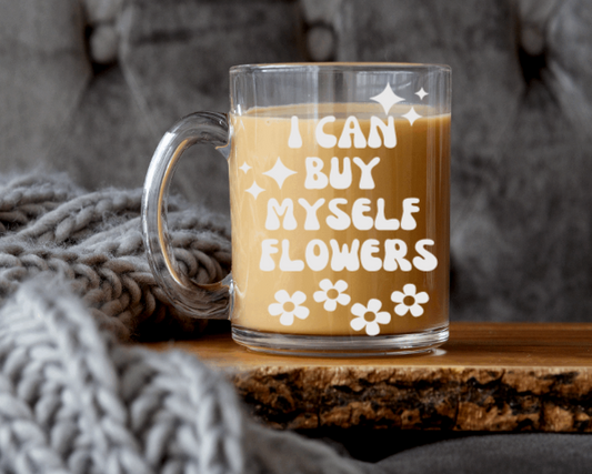 Taza de café de cristal con la frase "Puedo comprarme flores"